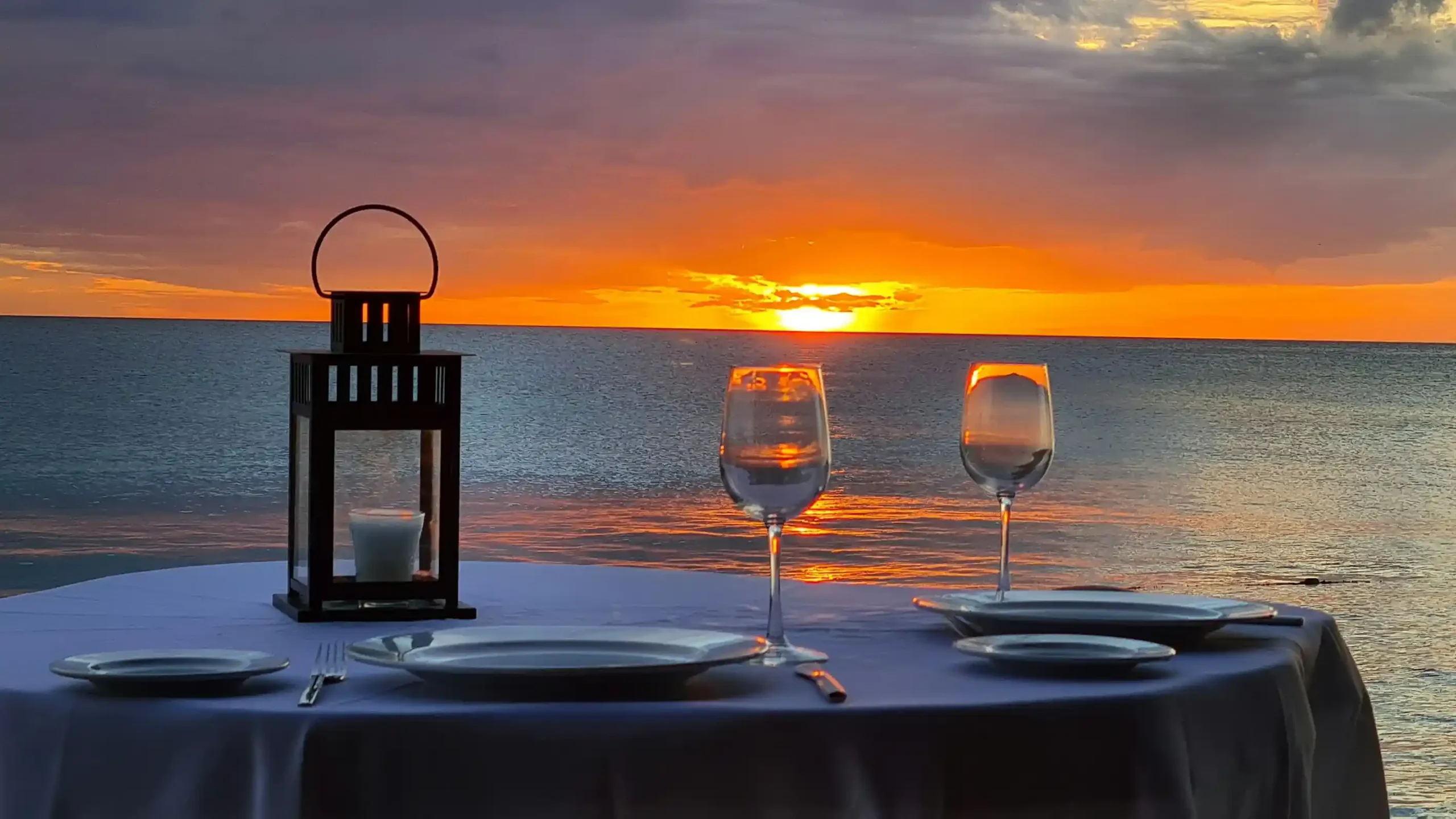 Candlelit dinner for two set on a Bali beach at dusk